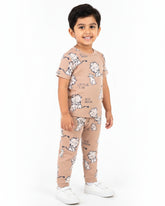 Child wearing a beige outfit with white dog prints on a white background